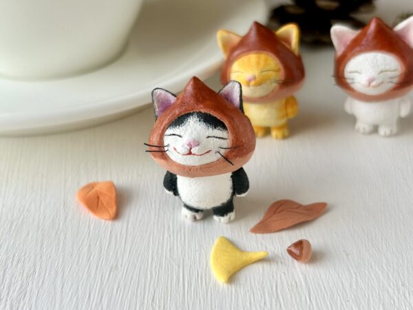 栗をかぶった白黒猫さん。粘土製の小さな置物。